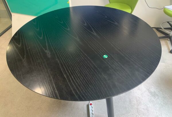 Table ronde connectée en bois stratifié noir de diamètre 140 cm. Localisation : 9 avenue Percier 75008 Paris