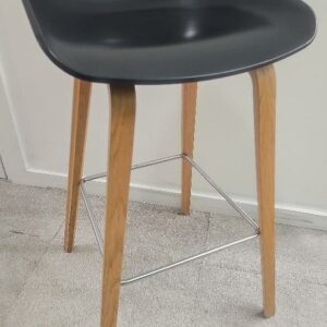 Tabouret haut de marque Hay, assise en plastique noir piétement en bois type chêne clair, repose pieds en métal brossé. 17 unités vendues avec faculté de réunion. Localisation : 9 avenue Percier 75008 Paris