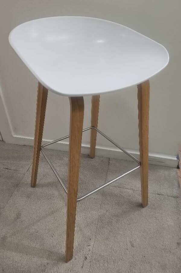 Tabouret haut de marque Hay, assise en plastique blanc, piétement en bois type chêne clair, repose pieds en métal brossé. 15 unités vendues avec faculté de réunion. Localisation : 9 avenue Percier 75008 Paris
