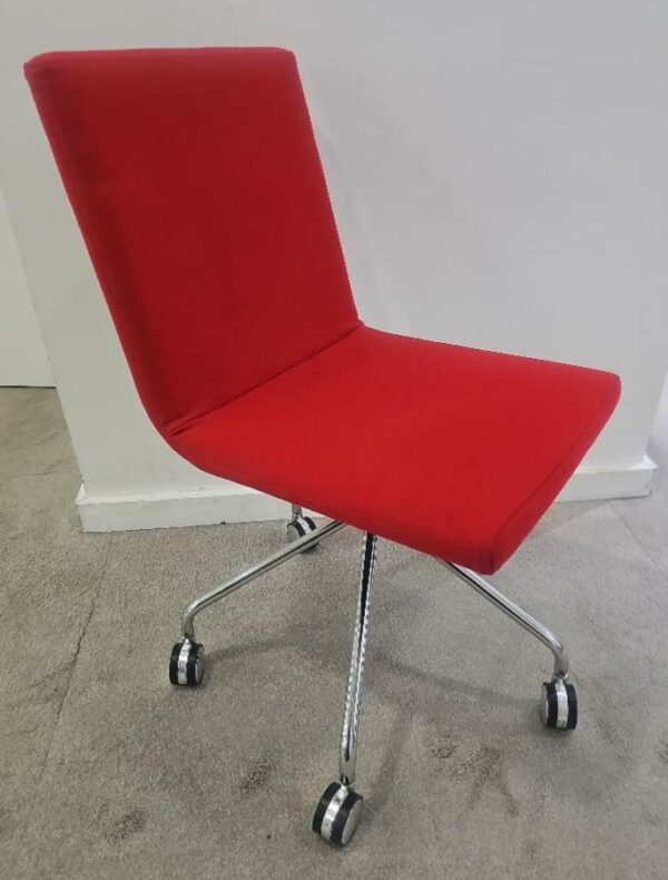 Chaise sur roulettes de marque Skandiform assise et dossier en tissu de couleur rouge piétement en étoile à 5 branches chromées. 4 unités vendues avec faculté de réunion. Localisation : 9 avenue Percier 75008 Paris