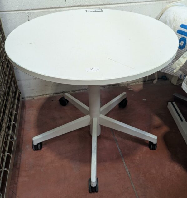 Table ronde sur roulettes, plateau en bois stratifié blanc, piètement en étoile à 5 branches en acier laqué blanc. 75 x 80 cm. Localisation : 8 rue de la Fossé aux Leux 91700 Ste Geneviève des Bois