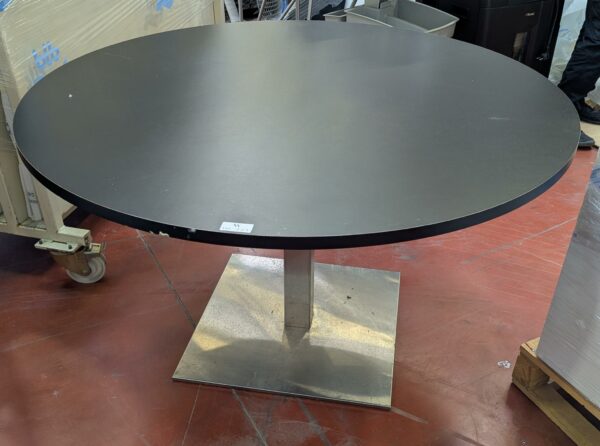 table ronde, plateau en bois stratifié noir sur pied colonne à section carrée. 77 x 130 cm. Localisation : 8 rue de la Fossé aux Leux 91700 Ste Geneviève des Bois