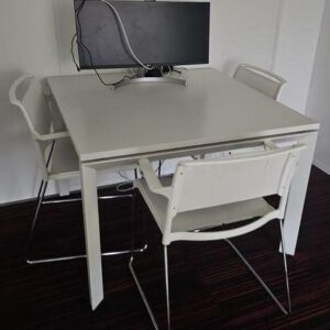 Table de réunion carrée en bois blanc ou type chêne clair et piétement blanc. Dimensions: 100 x 100 cm. Quantités disponibles: 57 unités.