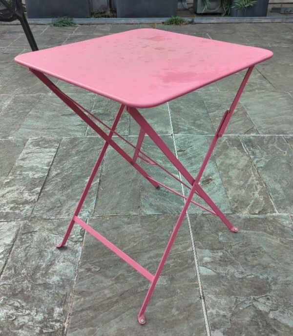 Table d'extérieur pliante en tôle de couleur rose. 75 x 57 x 57 cm. 13 unités. Vendu à l'unité avec faculté de réunion. Localisation : 32 rue de Monceau - 75008 Paris