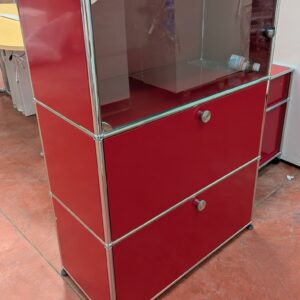 Meuble de marque USM HALLER de couleur rouge à 3 compartiments dont 1 ouvrant par 1 porte vitrée (fermée à clé) et 2 par portes à abattant. 109 x 77 x 38 cm. Localisation : 8 rue de la Fossé aux Leux 91700 Ste Geneviève des Bois