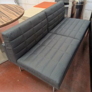 Canapé de marque Geiger modèle Tuxedo recouvert de tissu matelassé gris, piètement en métal. 77 x 142 x 70 cm. Localisation : 8 rue de la Fossé aux Leux 91700 Ste Geneviève des Bois – Image 2