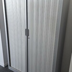 Armoire haute à porte rideaux coulissantes, couleur grise et top en bois couleur bois miel. Dimensions: 180 x 120 X 45 cm. Quantités disponibles: 750 unités. Localisation : 8 av. de Lunca - 78180 Montigny-le-Bretonneux.