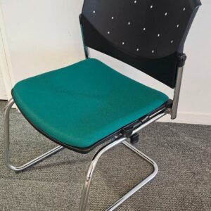 Chaise empilable visiteur de marque Dauphin modèle Eddy piètement luge empilable et chromé, assise en tissu vert, dossier en plastique noir. Quantités disponibles: 450 unités. Localisation : 8 av. de Lunca - 78180 Montigny-le-Bretonneux.