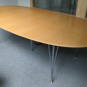 Table ovale design Arne Jacobsen, Piet Hein et Bruno Mathsson modèle Super Elliptique édition Fritz Hansen, plateau en bois couleur noyer, piètement en tiges d'acier chromé. 70 x 240 x 120 cm. Localisation : 10 rue Petit - 75019 Paris (1er)
