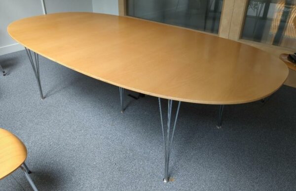Table ovale design Arne Jacobsen, Piet Hein et Bruno Mathsson modèle Super Elliptique édition Fritz Hansen, plateau en bois couleur noyer, piètement en tiges d'acier chromé. 70 x 240 x 120 cm. Localisation : 10 rue Petit - 75019 Paris (1er)