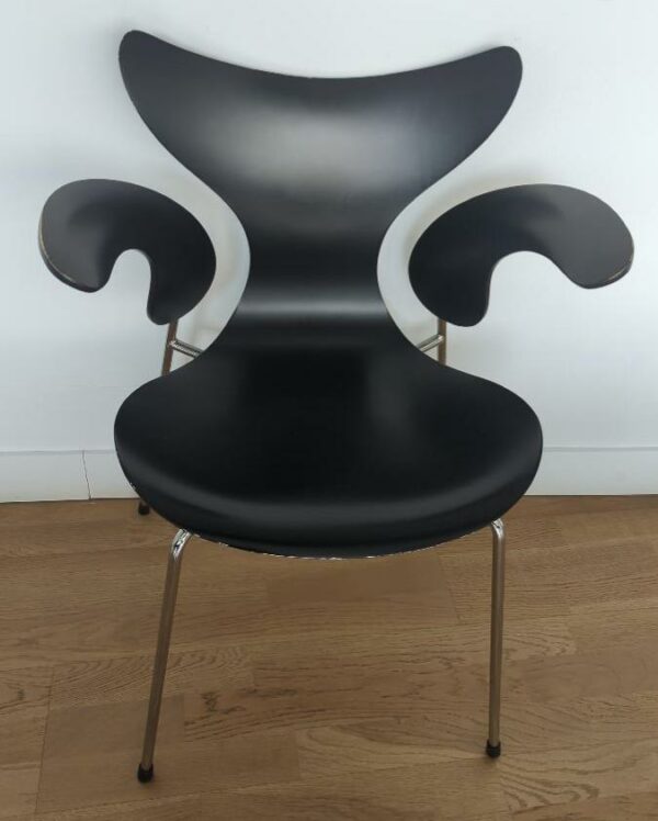 Fauteuil empilable design Arne Jacobsen modèle Lilly édition Fritz Hansen en bois noirci, structure en acier chromé. (usures). 76 x 60 x 50 cm. 10 unités. Vendu à l'unité avec faculté de réunion. Localisation : 10 rue Petit - 75019 Paris (3eme, ssol).