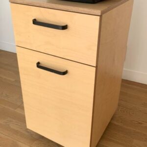 Meuble sur roulettes en bois clair ouvrant par un tiroir et une porte. 90 x 50 x 45 cm. Localisation : 10 rue Petit - 75019 Paris (3eme)