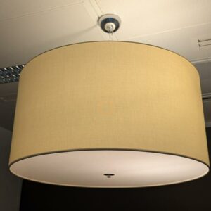 Suspension lumineuse de marque MODO modèle Cilindro, abat-jour en tissu blanc cassé, 3 ampoules, disque en plexiglas. Dimensions abat-jour : 36 x 67 cm. 32 unités. Vendu à l'unité avec faculté de réunion. Localisation : 2 est, 3 est, 4 est, 5 est, 5 ouest, 6 est, 6 ouest.