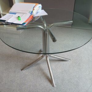 Table ronde plateau en verre transparent reposant sur un piètement à 4 branches en acier tubulaire chromé. 71 x 110 cm. Localisation : 6 rue Duret - 75116 Paris : 1-37