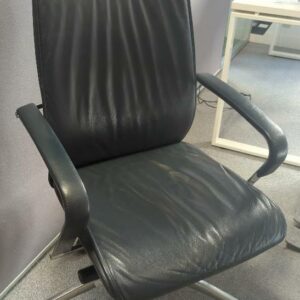 Fauteuil de direction pivotant ajustable en hauteur en cuir bleu nuit. piètement en étoile à 5 branches sur roulettes. 119 x 61 x 66 cm. Localisation : 6 rue Duret - 75116 Paris : es13