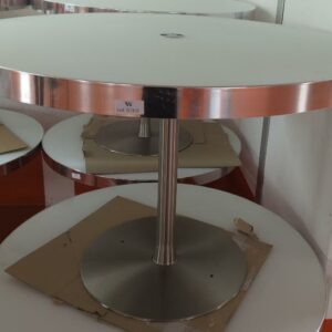 Table ronde avec trappe technique centrale, plateau en bois stratifié et verre fumé blanc cerclé d'inox reposant sur un piètement en acier chromé. 74 x 111 cm. 7 unités. Vendu à l'unité avec faculté de réunion. Localisation : 5 avenue Kleber - 75116 Paris – Image 3