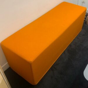Banquette de marque Buzzi Space modèle Buzzi Cube recouverte de tissu orange mandarine. 46 x 138 x 47 cm. Localisation : 10 rue Petit - 75019 Paris (1er)