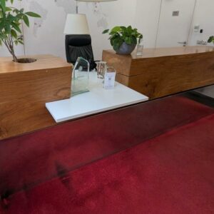 Comptoir ou banque d'accueil composé d'un billot de bois découpé et plaque de métal en partie basse côté public, et un espace de travail en bois stratifié blanc avec niches et étagères côté privé. 110 x 330 x 130 cm. Localisation : 6 rue Duret - 75116 Paris (hall)