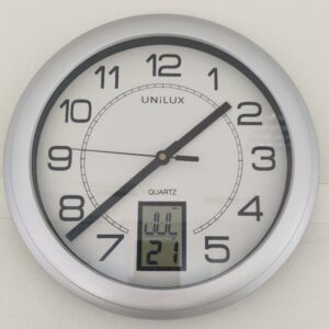 Horloge murale à quartz de marque Unilux modèle Instinct, avec dateur digital, cadre gris. 14 unités. Vendu à l'unité avec faculté de réunion. (1er bat A : 8 / RDC bat A : 7 / SS bat A : 1 / Bat B : 1)