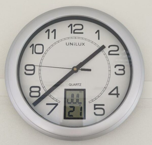Horloge murale à quartz de marque Unilux modèle Instinct, avec dateur digital, cadre gris. 14 unités. Vendu à l'unité avec faculté de réunion. (1er bat A : 8 / RDC bat A : 7 / SS bat A : 1 / Bat B : 1)