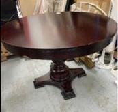 Table ronde en bois foncé couleur acajou reposant sur un pied central balustre. 75 x 112 cm. (usures) Localisation: 10 rue du Ballon - 93160 Noisy-Le-Grand