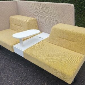 Banquette de marque Ophelis en tissu jaune et beige sur roulettes avec cloison haute, 2 assises, tablette centrale rotative, 1 trappe de rangement. 110 x 214 x 95 cm. Tablette rotative : 60 x 26 cm. Localisation : 30 rue Beauregard 60440 Nanteuil-le-Haudouin.