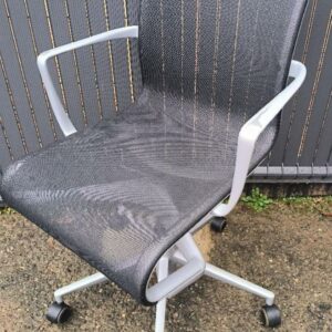 Fauteuil de bureau pivotant sur roulettes de marque Alias, dossier et assise en résille noire, accoudoirs en métal gris et piétement en étoiles 5 branches en métal gris. 95 x 56 x 60 cm. (usures aux accoudoirs). Localisation : 30 rue Beauregard 60440 Nanteuil-le-Haudouin.