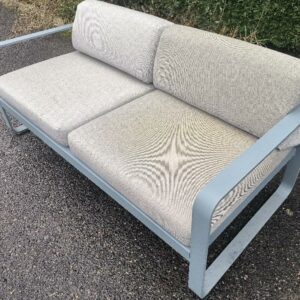 Canapé extérieur 2 places design Pagnon et Pelhaître modèle Bellevie édition Fermob, structure en aluminium gris, assise et dossier recouvert de tissu outdoor acrylique gris. 71 x 160 x 75 cm. (usures). Localisation : 30 rue Beauregard 60440 Nanteuil-le-Haudouin