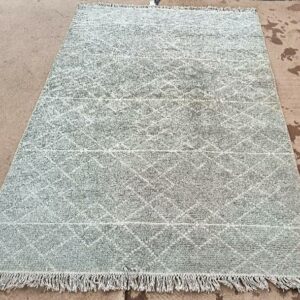 Tapis noué à la main à fond beige et gris, motifs géométriques blancs. (tâches). Dim : 136 x 212 cm. Localisation : 30 rue Beauregard 60440 Nanteuil-le-Haudouin