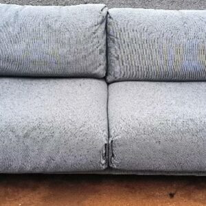 Canapé recouvert de tissu de couleur gris, piétement en bois naturel, assise et dossier amovible et déhoussable. Dim : 70 x 200 x 100 cm. Localisation: 30 rue Beauregard 60440 Nanteuil-le-Haudouin.