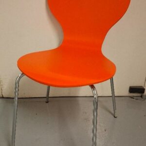 Chaise empilable dans le goût du modèle Ant de Arne Jacobsen, coque en bois laqué orange vif,  piétement en acier tubulaire chromé.  85 x 43 x 58 cm. (usures aux assises). 8 unités. Localisation: -1 réserve