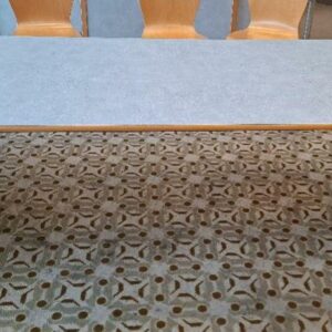 Table 6 personnes, plateau rectangulaire en bois stratifié moucheté bleu, piétement en bois et métal. 74 x 180 x 80 cm. 32 unités. Localisation: Rie