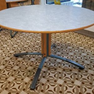 Table ronde 4 personnes, plateau en bois stratifié moucheté bleu, piétement en bois et métal. 74 x 120 cm. 11 unités. Localisation: Rie