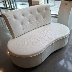 Canapé en cuir blanc, assise de forme haricot, dossier capitonné. 90 x 146 x 80 cm. Localisation: 19 rue Neuve Tolbiac - 75013 Paris (Hall accueil)