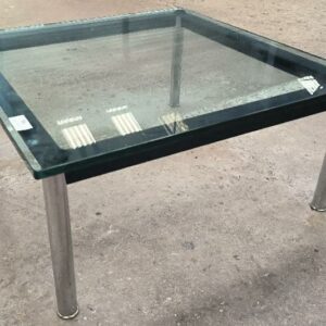 Table basse dans le goût du modèle ​​LC10 design Le Corbusier, plateau en verre, structure en métal émaillé et chromé. Dim : 33 x 70 x 70 cm. Localisation : 34 avenue du Général Patton 02880 Crouy