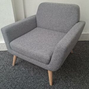 Fauteuil de marque Softline recouvert de tissu gris, piétement en bois naturel. 72 x 84 x 75 cm. Localisation: 30 rue Beauregard - 60440 Nanteuil-Le-Haudouin