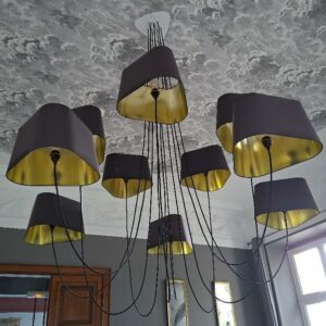 Lustre design Hervé Langlais modèle 10 nuages édition Design Heure, réglable en hauteur et en diamètre, abat-jours triangulaires en satin doré et noir. Localisation: BLB, 3 rue de la Fossé aux Leux - 91700 Sainte Geneviève des Bois