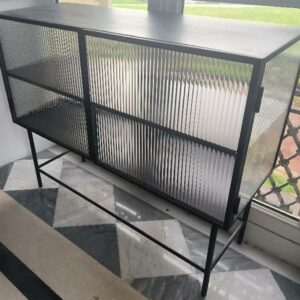 Vitrine design Says Who modèle Haze édition Ferm Living en métal noir et verre ouvrant par 2 portes battantes sur 2 étagères. Dim : 90 x 110 x 40 cm. Localisation: BLB, 3 rue de la Fossé aux Leux - 91700 Sainte Geneviève des Bois