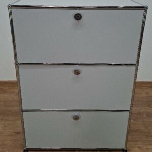 Meuble de rangement de marque USM HALLER de couleur gris perle composé de 3 modules dont 2 ouvrants à portes à abattant et 1 à tiroir coulissant. 109 x 77 x 37 cm. 3 unités. Vendu à l'unité avec faculté de réunion. Localisation: 8 rue de la Fossé-aux-Leux, 91700 Ste Geneviève des Bois.