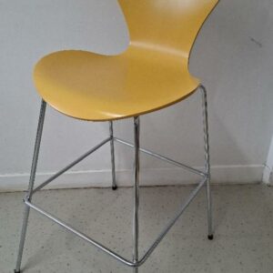 Chaise haute empilable design Arne Jacobsen modèle Série 7, édition Fritz Hansen, coque en bois laqué couleur jaune égyptien, piétement en acier chromé avec repose-pieds. 110 x 46 x 60 cm. Localisation: 54 avenue Philippe Auguste - 75011 Paris