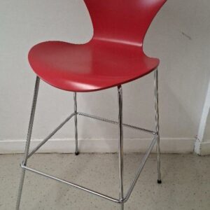 Chaise haute empilable design Arne Jacobsen modèle Série 7, édition Fritz Hansen, coque en bois laqué couleur rouge opium, piétement en acier chromé avec repose-pieds. 110 x 46 x 60 cm. Localisation: 54 avenue Philippe Auguste - 75011 Paris