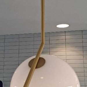 Suspension design Michael Anastassiades modèle IC édition Flos, structure en laiton, globe en verre opalin blanc. 77 x 42 cm. Localisation: 48 rue Cambon - 75001 Paris