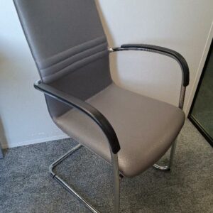 Fauteuil visiteur empilable de marque Kusch+Co, garniture en cuir gris, supports d’accoudoirs en plastique noir, piétement en porte à faux en acier chromé. 95 x 57 x 62 cm. 96 unités. Vendu à l'unité avec faculté de réunion. Localisation: 48 rue Cambon - 75001 Paris