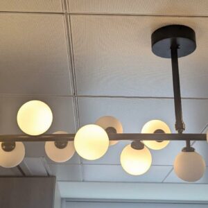 Suspension lumineuse design Gwendolyn et Guillane Kerschbaumer modèle Mimosa édition Areti en métal noir, à 19 globes en verre opalin. 60 x 110 cm. Localisation : 48 rue Cambon - 75001 Paris