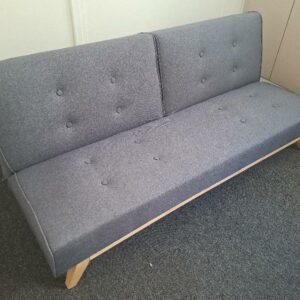Canapé convertible en banquette lit recouvert de tissu capitonné gris, piétement en bois naturel. 74 x 177 x 72 cm. Déplié  largeur 96 cm. 2 unités. Vendu à l'unité avec faculté de réunion. Localisation : 30 rue Beauregard - 60440 Nanteuil-le-Haudouin