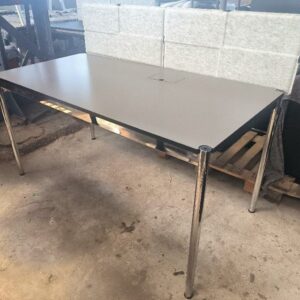 Bureau de marque USM HALLER de couleur gris, plateau en linoléum nero avec trappe reposant sur un cadrage et un piètement en acier chromé, réglable en hauteur, séparateur en feutrine gris. Dim : 75 x 150 x 76 cm. 2 unités. Vendu à l'unité avec faculté de réunion. Localisation : 34 avenue du Général Patton 02880 Crouy