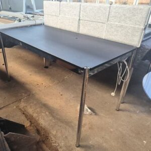 Bureau de marque USM HALLER de couleur noir, plateau en linoléum nero avec trappe reposant sur un cadrage et un piètement en acier chromé, réglable en hauteur, séparateur en feutrine gris. Dim : 75 x 150 x 76 cm. 2 unités. Vendu à l'unité avec faculté de réunion. Localisation : 34 avenue du Général Patton 02880 Crouy