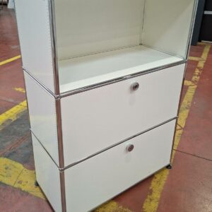 Meuble de rangement de marque USM HALLER de couleur blanche à une niche et 2 compartiments ouvrants par porte à abattant, une face latérale perforée. 109 x 77 x 37 cm. Localisation : 8 rue de la Fossé-aux-Leux - 91700 Sainte Geneviève des Bois.