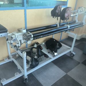 Table médicale d’extension orthopédique de marque TASSERIT sur roulettes, supports rembourrés pour membres inférieurs et accessoires de positionnement. Dim : 110 x 235 x 72 cm. (RDC)