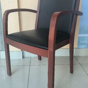 Fauteuil en bois de couleur merisier, avec assise et dossier en simili cuir noir. Dim : 85 x 57 x 50 cm. 3 unités. Vendu à l'unité avec faculté de réunion. (RDC)